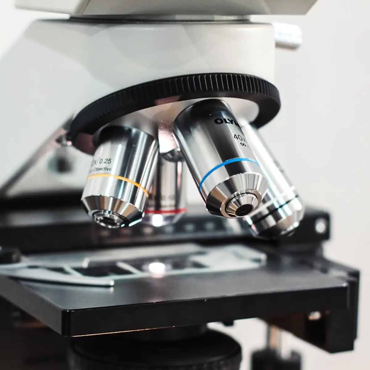 Close-up of a microscope objective turret over a slide stage.
